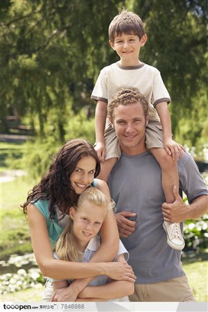 幸福家庭-外国家庭一家四口骑在爸爸背着的儿子和搂着妈妈怀里的女儿