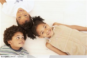 幸福家庭-黑皮肤卷发的三个外国小孩躺在地板上
