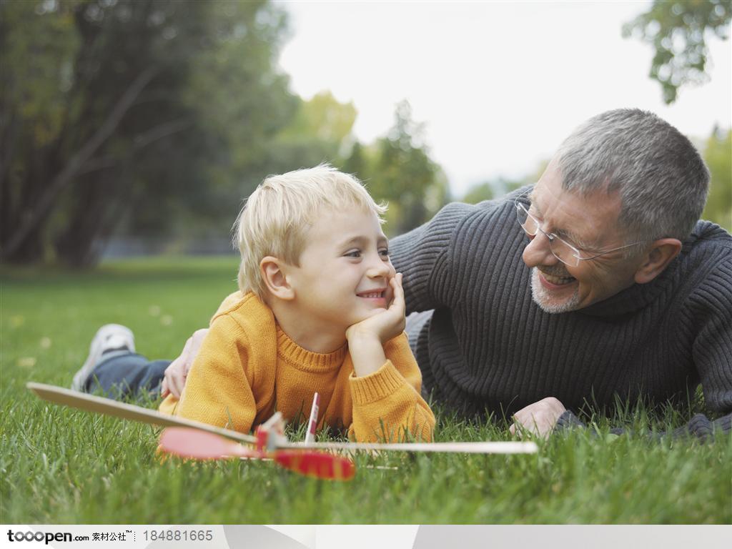 长辈与孩子-趴在草地上的爷爷和孙子