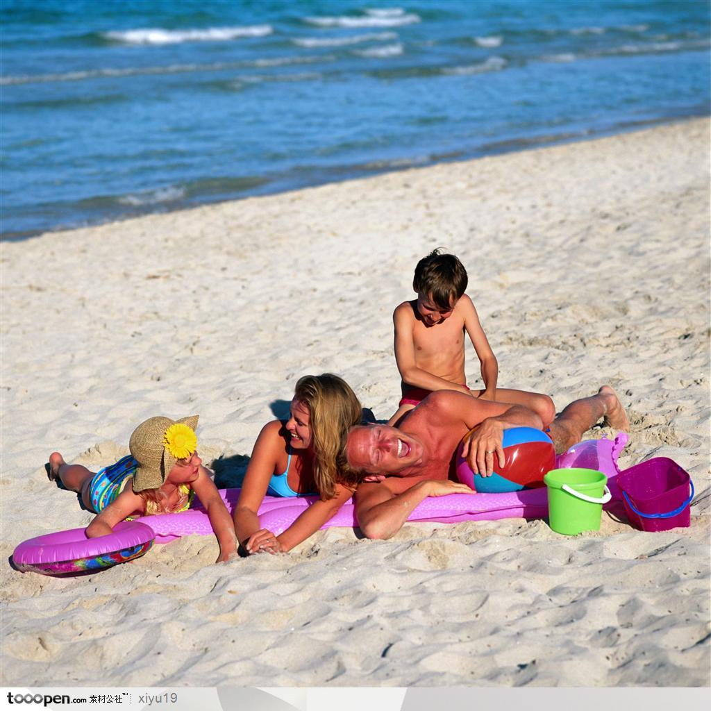 海滩休闲生活-沙滩上玩耍的一家人