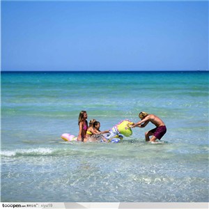 海滩休闲生活-海滩上玩耍的一家人