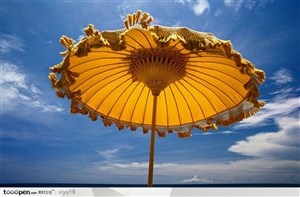 海滩休闲生活-蓝天下的黄色遮掩伞