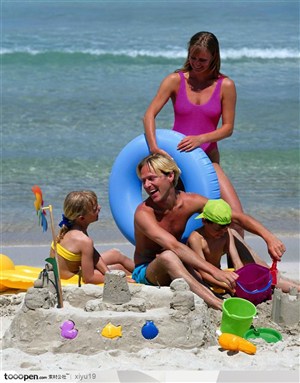 海滩休闲生活-沙滩上玩耍的一家人