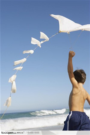 家庭海滩旅-在海边放风筝的小男孩
