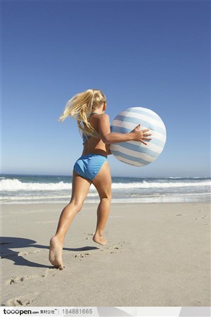 穿比基尼拿着球在沙滩上奔跑的外国女人