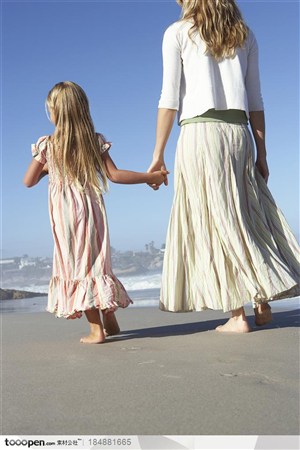 穿着裙子的母女两在海边散步