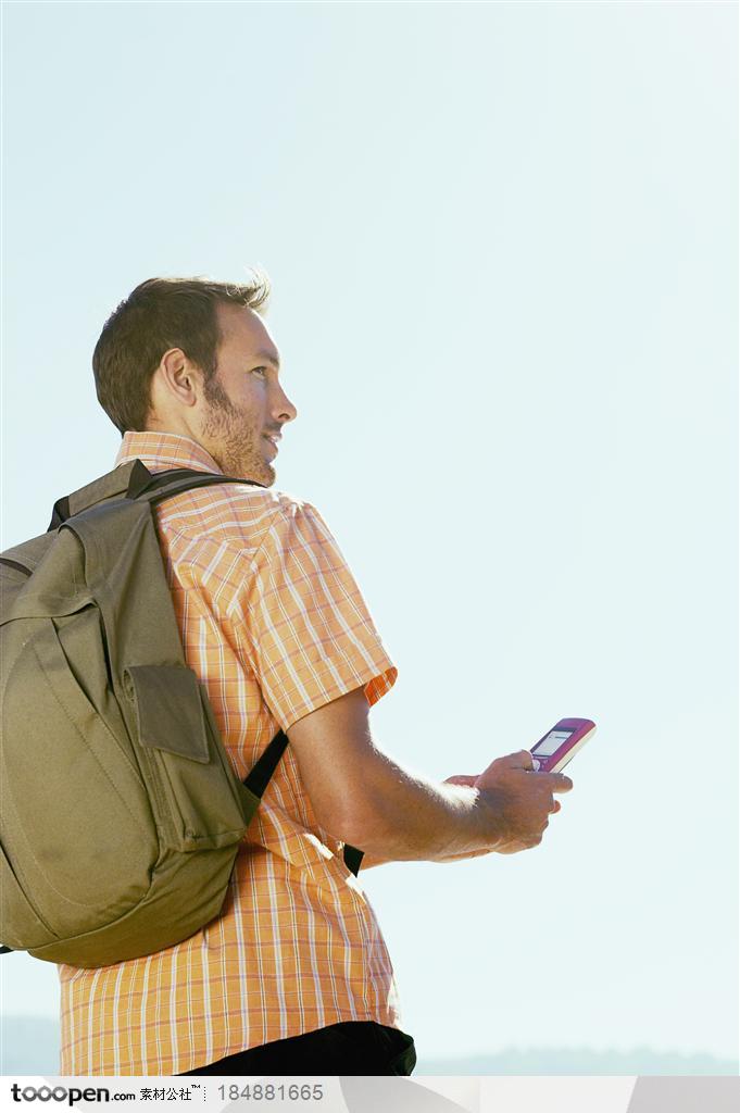 户外探险露营生活-背着背包拿着手机的外国男人