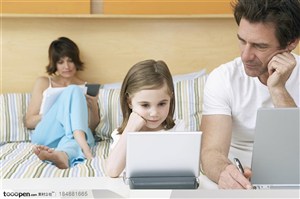 数码生活-外国家庭爸爸看着女儿使用电脑妈妈坐在后面使用计算器