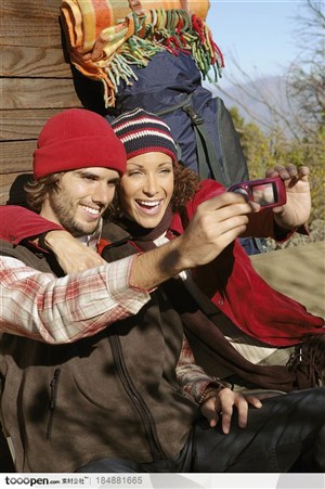 户外探险露营生活-坐在小木屋外自拍的外国夫妻