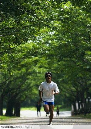 比赛运动-树荫间跑步的运动员