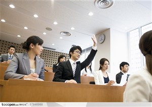 商业培训-在台下听讲的学员举手提问或回答问题