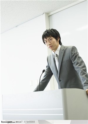 商业培训-穿灰色西装的培训老师站在讲台前