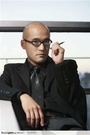 商务表情-坐在椅子上把笔握在手中的职场男士