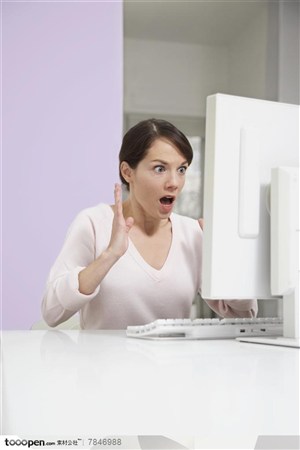 商务表情-在办公桌的电脑前做出惊恐表情的外国职场女性