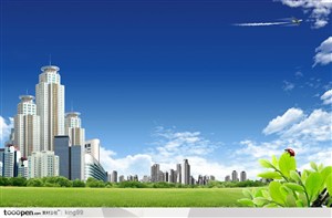 绿色草地上矗立的现代高楼大厦和蓝天白云背景