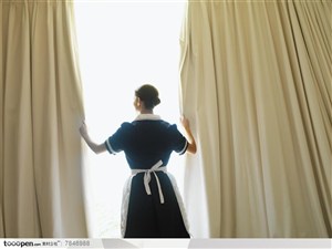 入住星级酒店-站在窗户边拉窗帘的女服务员
