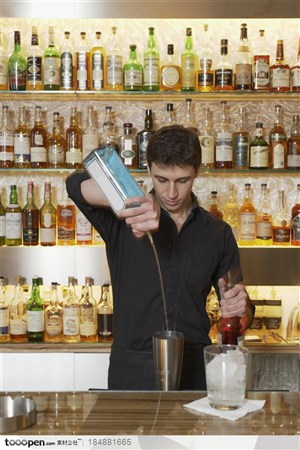 工作中的年轻人-拿着蓝色酒杯调酒的帅哥调酒师