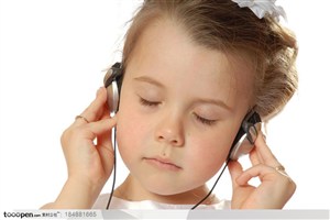闭上双眼的外国小女孩戴着耳麦在听音乐