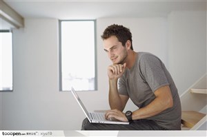 公寓生活-坐在楼梯上玩电脑的男人