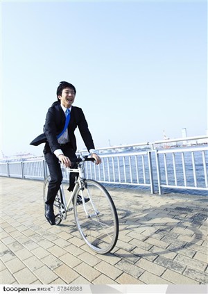 雄心勃勃的年轻人-穿西装的白领帅哥骑自行车在上班的路上