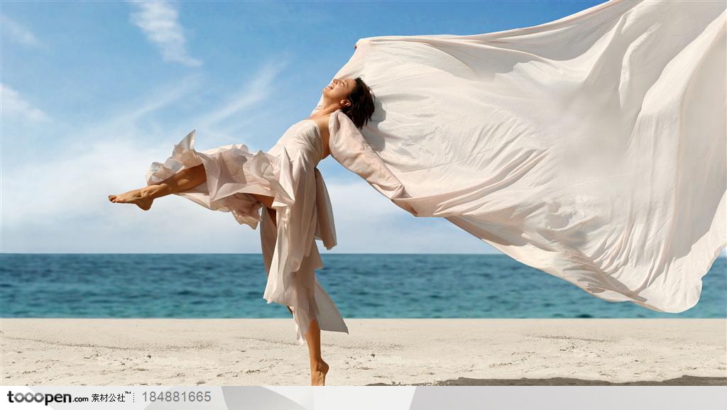 穿白色抹裙飘扬的披肩单脚腾空在沙滩上跨越