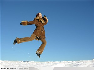 穿皮革大衣的国外美女在雪地上跳跃