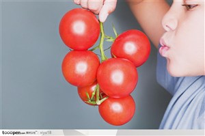 饮食习惯-拿着一串西红柿的男孩