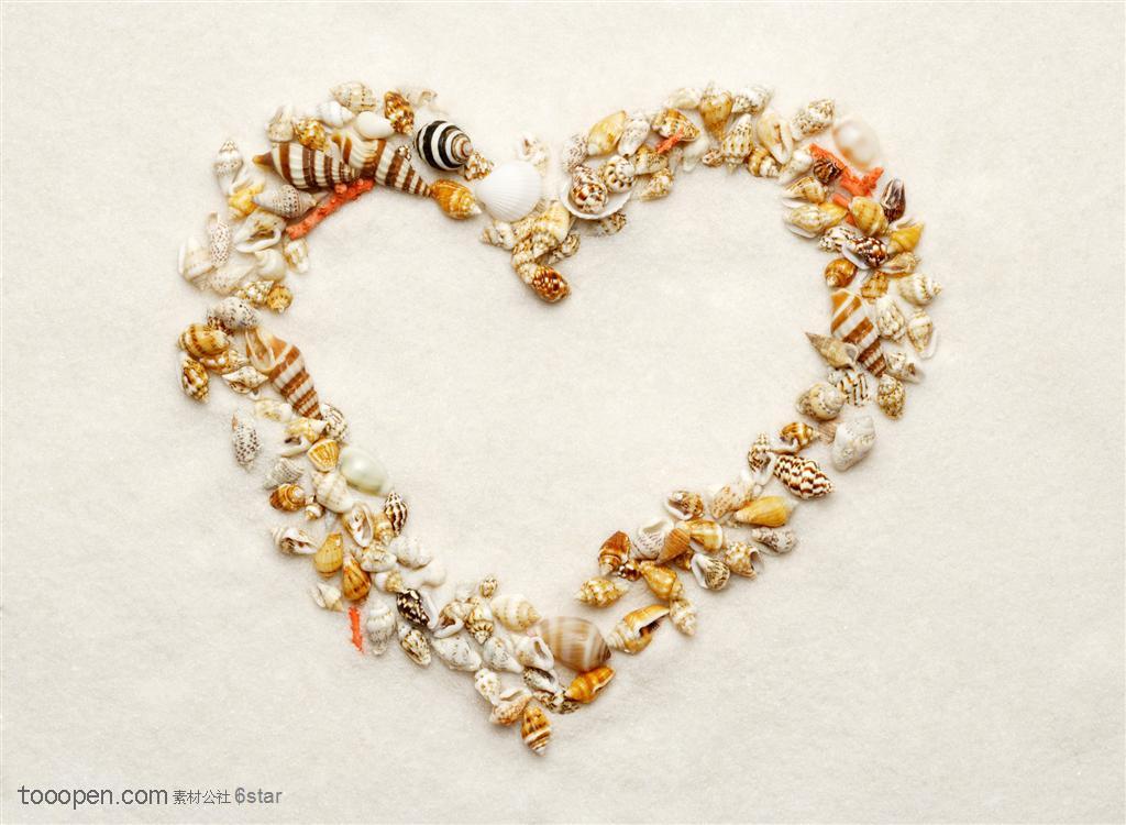 广告创意图形沙滩上贝壳拼成的心型