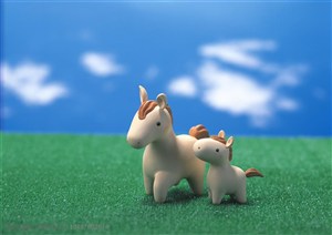 玩具-在蓝天白云下草地上的两只陶瓷小马