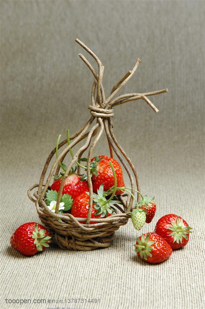 新鲜水果-放在麻布袋上的草莓及藤条工艺品里装着的新鲜草莓