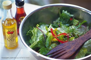 营养美食-在厨房案板上摆着金属盆里的蔬菜沙拉和橄榄油和香料