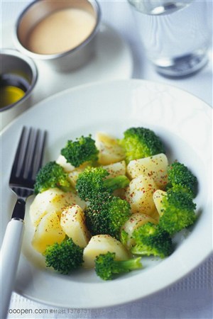 营养美食-圆形餐盘上放在西兰花和土豆块边上还摆放着叉子
