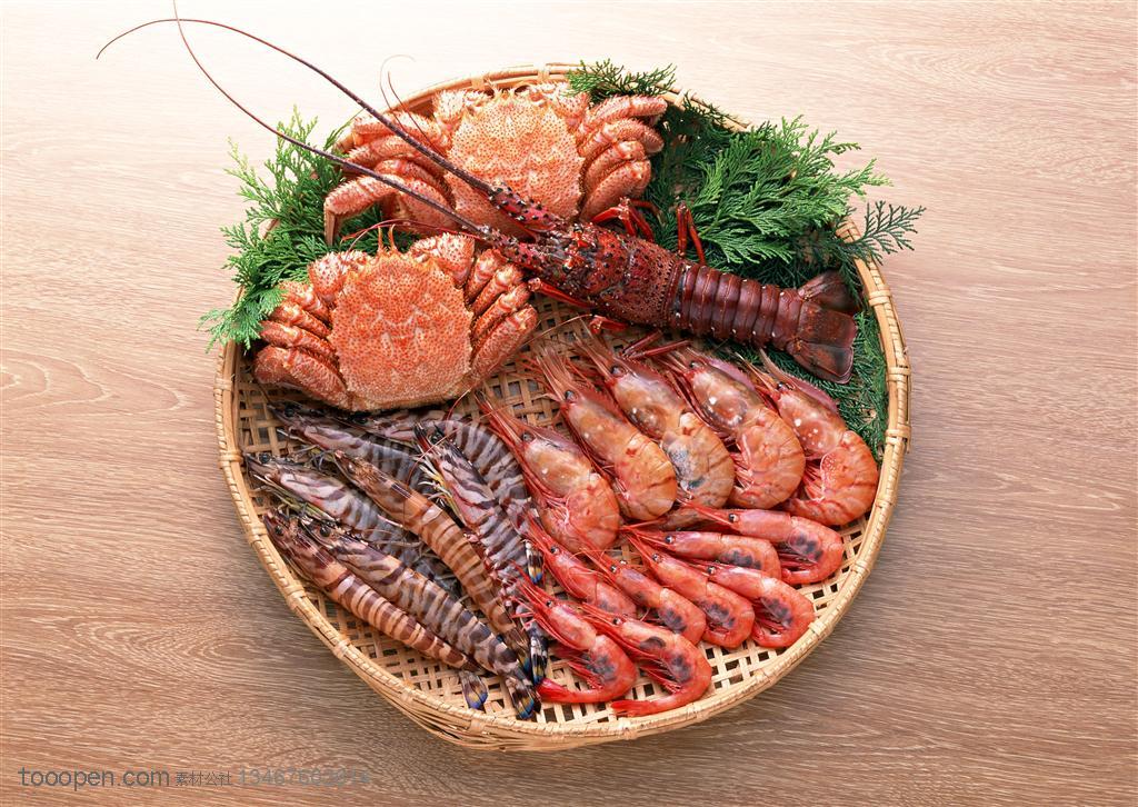 放在簸箕里的两只大螃蟹、基围虾、大龙虾等海鲜