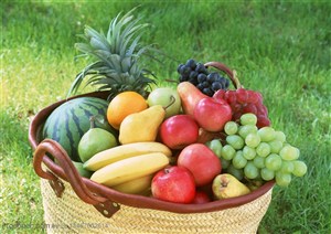 新鲜水果-摆在草地上的竹编篓子里的葡萄、香蕉、西瓜、菠萝、苹果等新鲜水果
