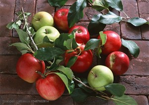 新鲜水果-放在红砖上带叶子的红苹果和青苹果