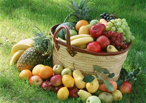 摆放在草地上的水果和竹编制篮里的新鲜水果特写