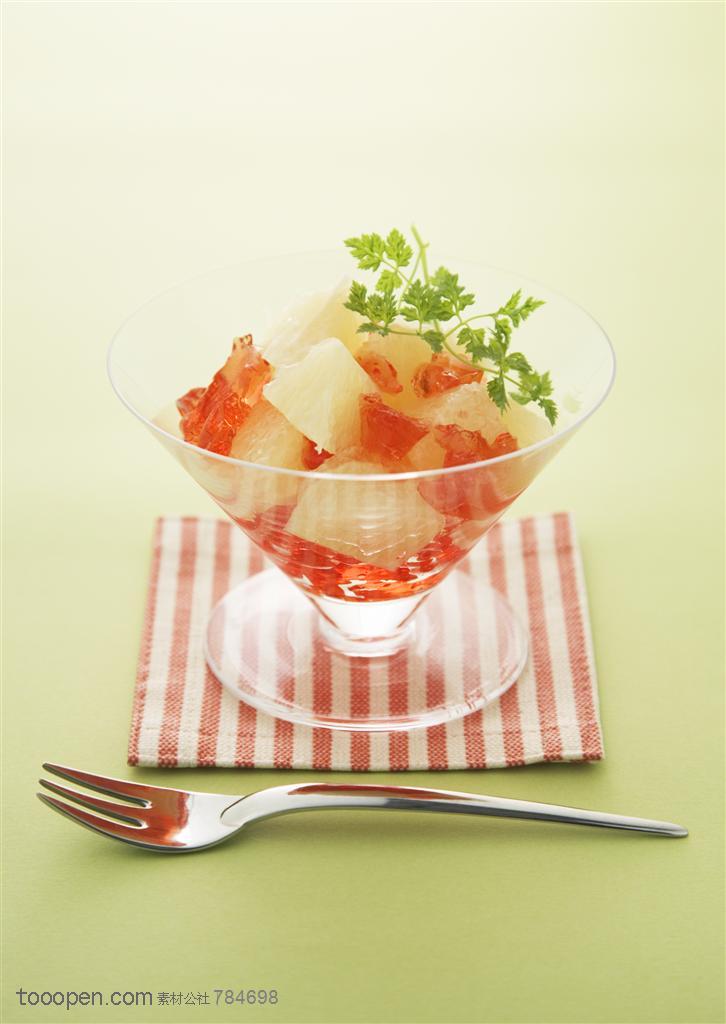 水果拼盘-摆放在桌子上的一杯水果沙拉和叉子