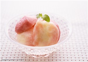 水果拼盘-碗里装的水蜜桃果肉上面有两片薄荷叶