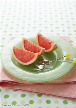 水果拼盘-盘子里的三瓣胡柚和两把叉子