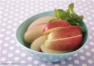 水果拼盘-蓝色的碗里装着苹果条和薄荷叶