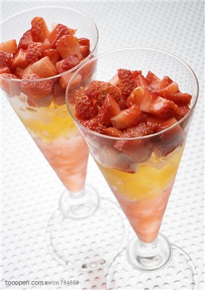 水果拼盘-两个锥型杯里装着果汁和切碎的草莓