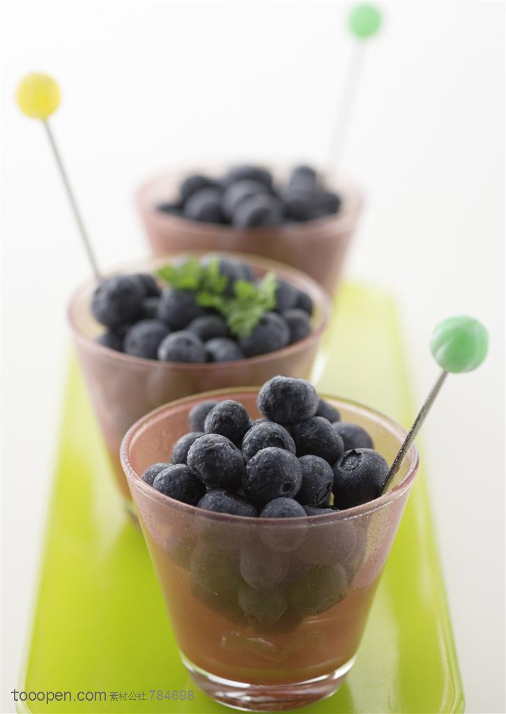 水果拼盘-装在谈绿色长方形盘子里的三个杯子里装着蓝莓