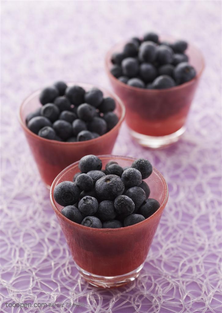 水果拼盘-桌面上摆放着三杯蓝莓特写
