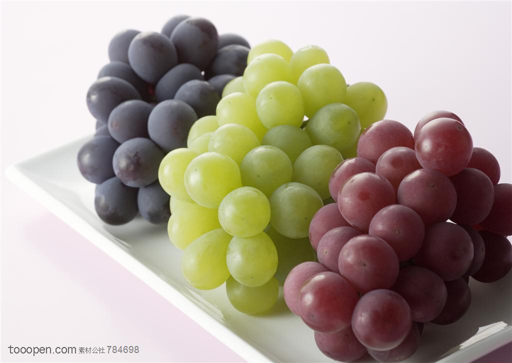 水果拼盘-长方形的盘子里摆放着三串葡萄