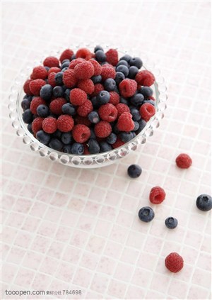 水果拼盘-俯视洒在桌面上及装在碗里的红树莓和蓝莓