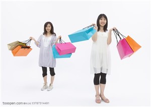 青春活力-两个提着购物袋的女孩