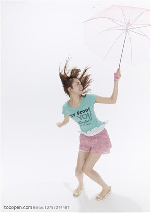 青春活力-拿着伞被风吹起头发的女孩