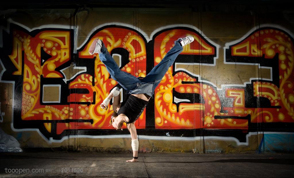 舞蹈特写-在街道涂鸦的墙体前跳舞的外国男孩