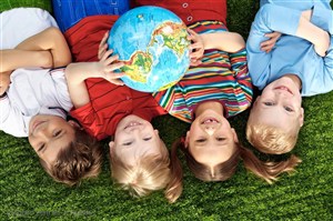 快乐儿童图片素材抱着地球躺在草地上的四个儿童
