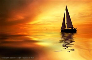 金色阳光中静静的海面上的小型帆船